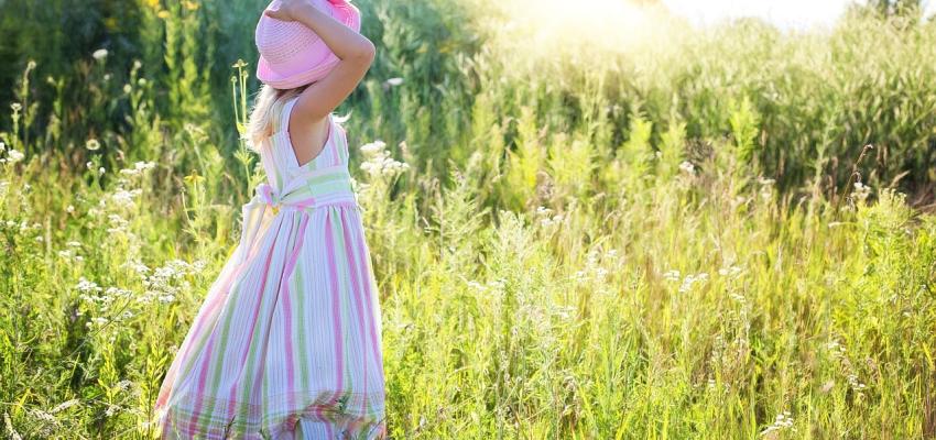 Young girl standing in field of flowers in summer